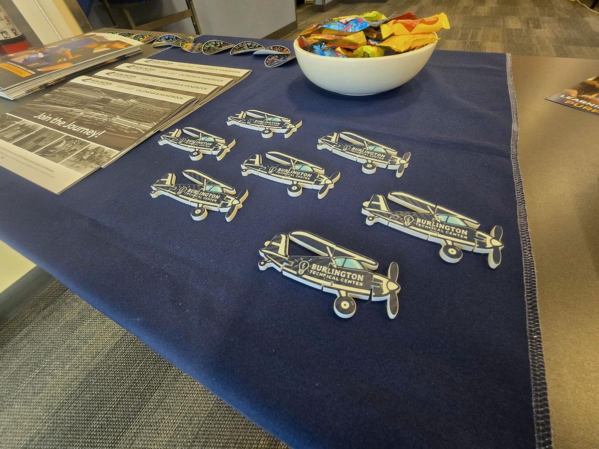 Burlington Technical Center airplane-shaped pieces arranged on a navy cloth